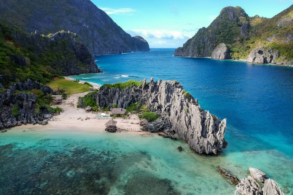 Couple watching sunset over limestone karsts in El Nido, Palawan Philippines