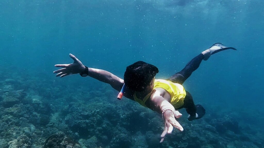 Freediver swimming over a tropical reef in the Philippines