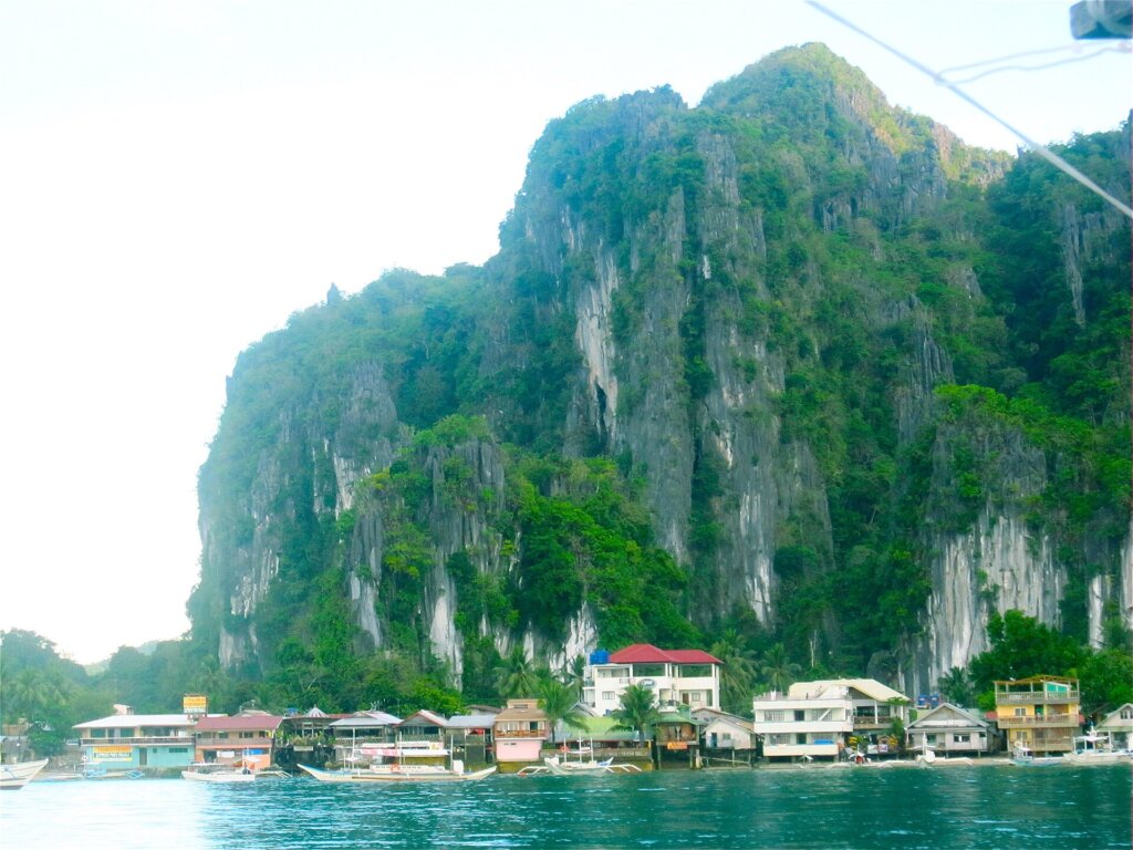 El Nido town beneath limestone cliffs, where hillside hotels sit