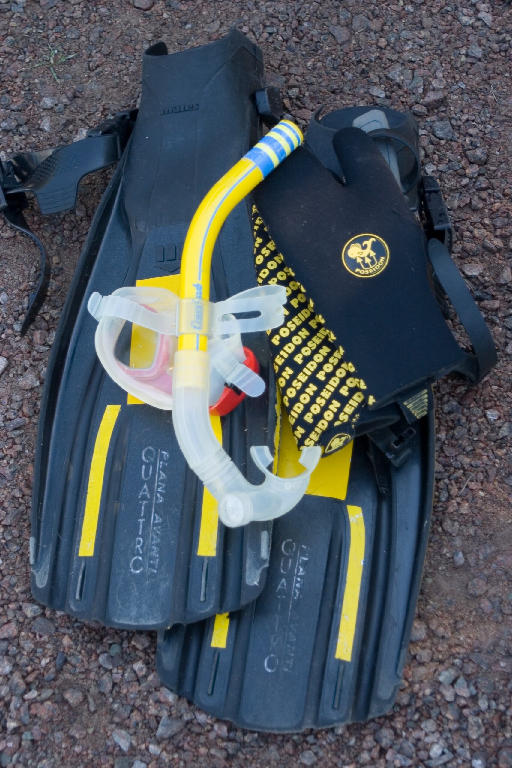 Snorkeling equipment including mask, snorkel and fins laid out before a swim