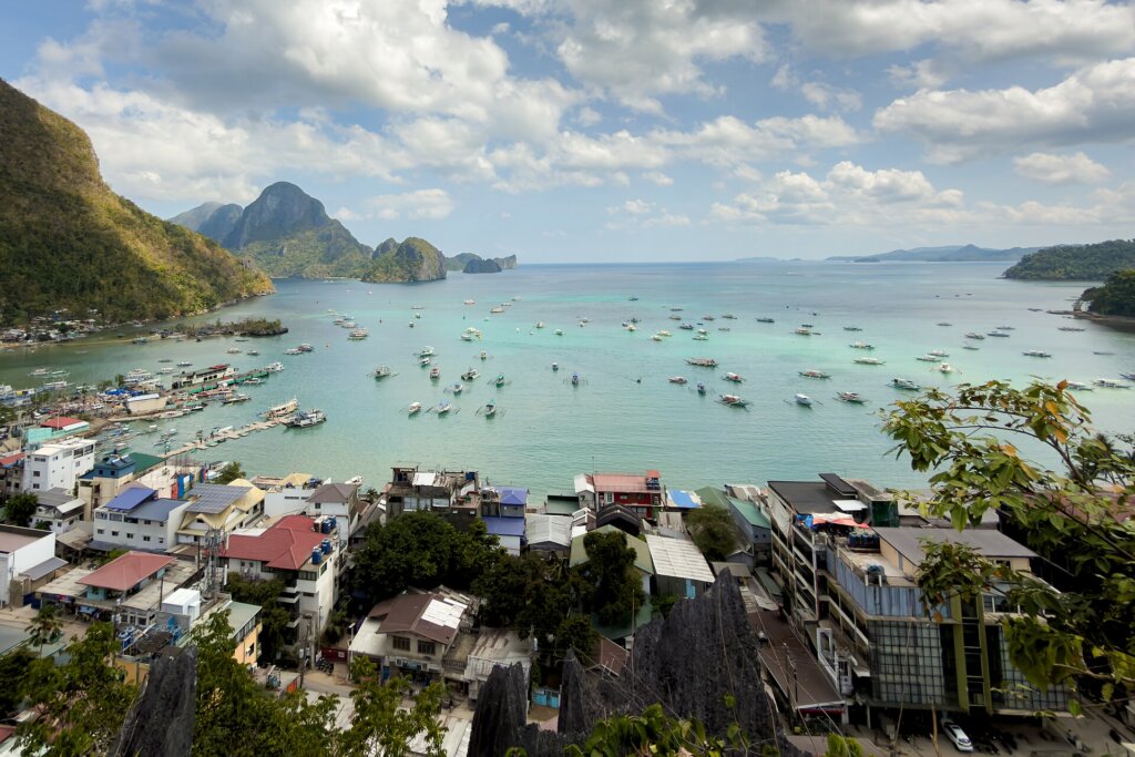 El Nido town beach with bangka boats and limestone cliffs